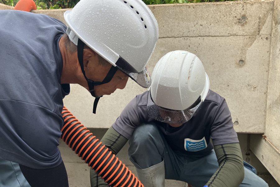 2人がかりで槽の中を確認しながら洗浄する作業員